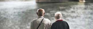 two older men looking at a bridge